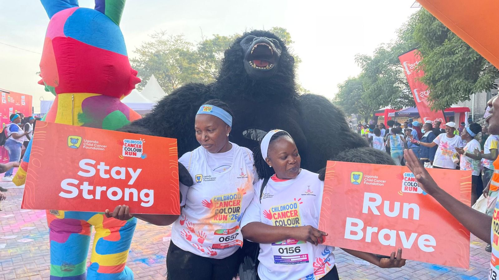Supporters holding Stay Strong and Run Brave signs at a charity run
