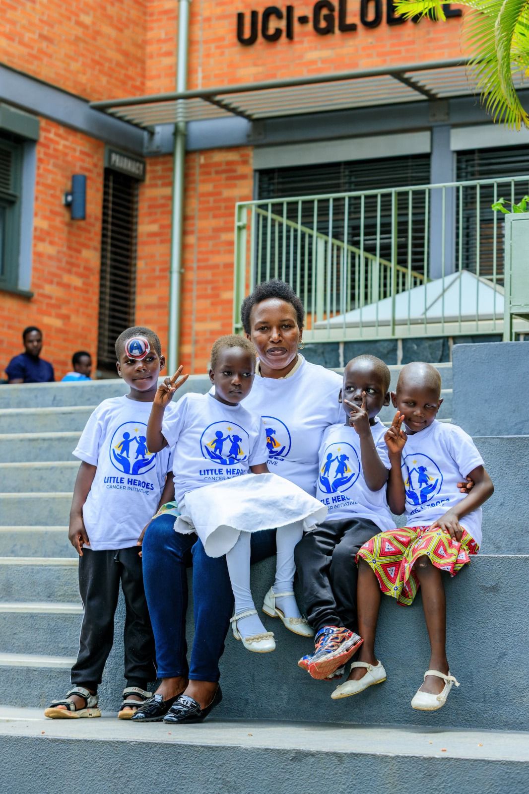 Little Heroes team and children in matching t-shirts on outdoor steps