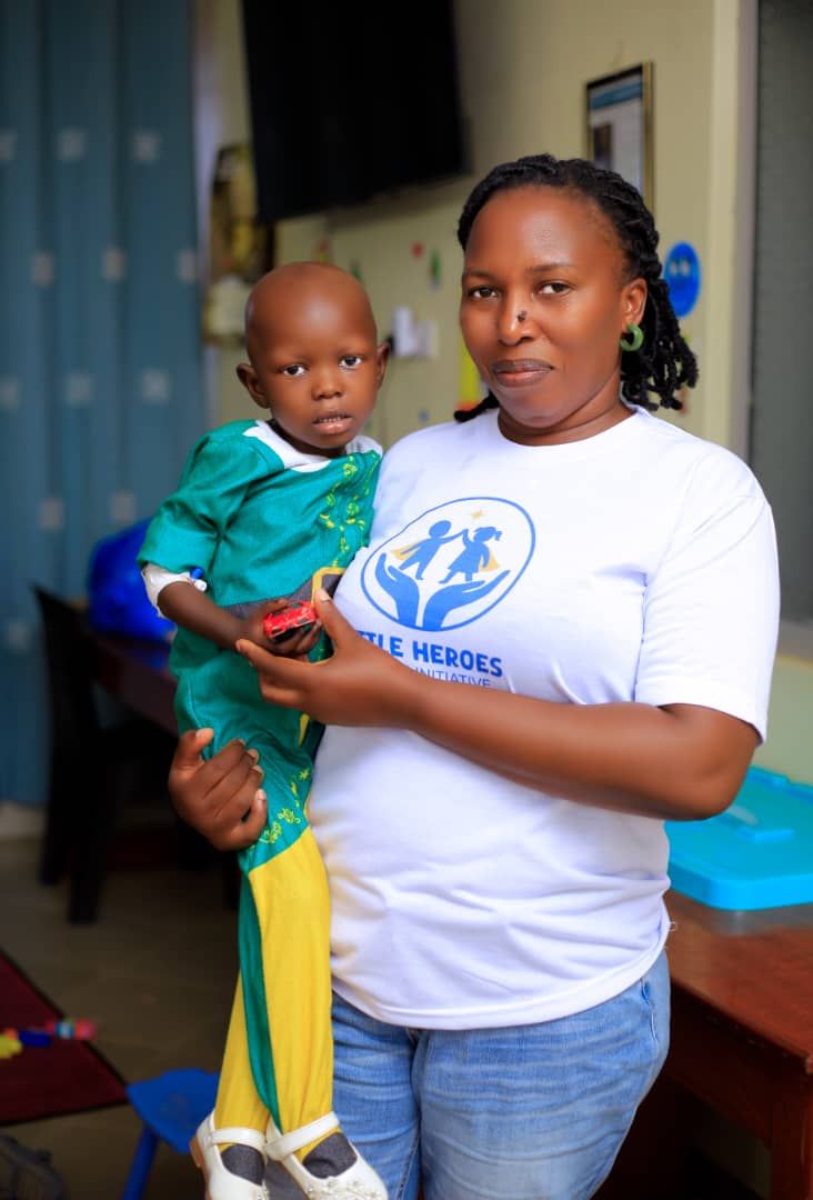 Team member holding a smiling toddler