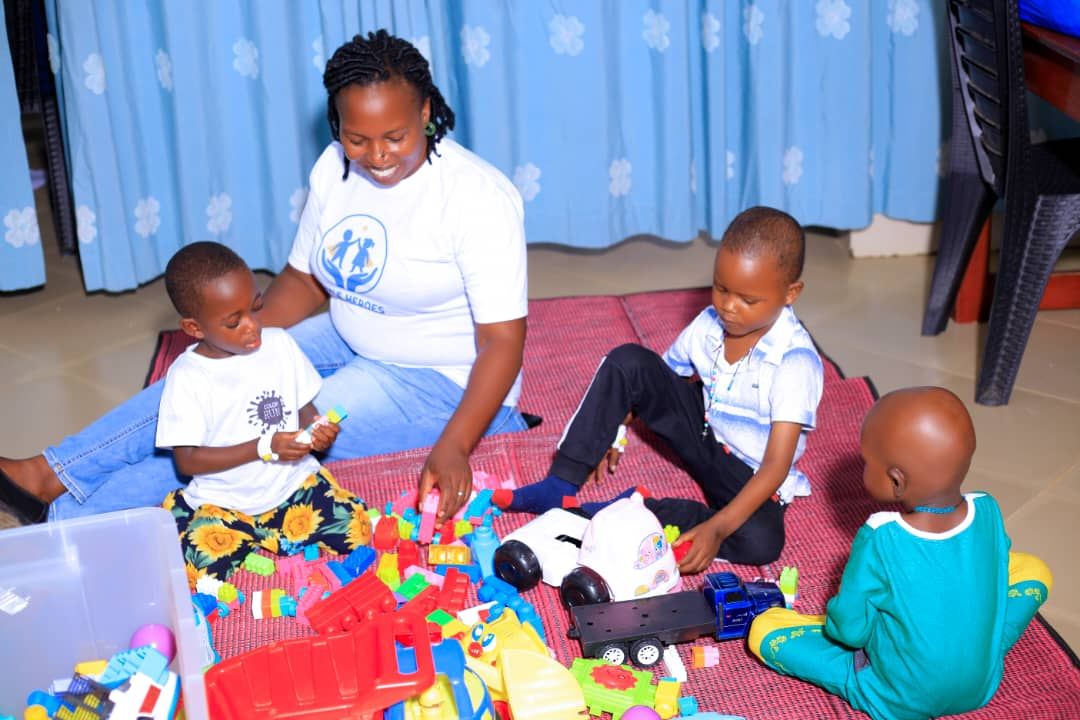 Team member playing with children on a colourful mat